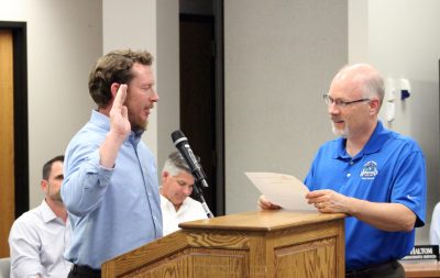 In front from left, Scott Beyer is sworn in Monday, July 23, as Howard's new trustee for Wards 9-10 by Administrative Services Director Chris Haltom.