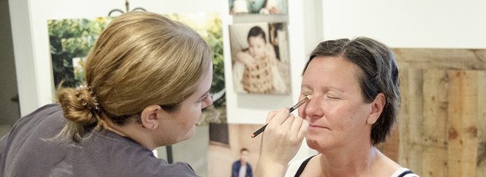 A breast cancer survivor getting her makeup done