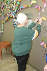 Simone Kriegl places her leaf on "The Survivor Tree" at the center, signaling completion of her radiation treatment.