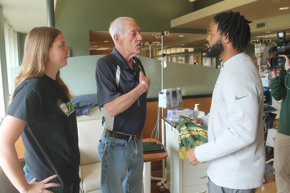 Ed La Tour, of Green Bay, speaks with Keisean Nixon in the treatment area of the Bellin Cancer Team facility, as La Tour's granddaughter, Breanna Hock, listens in.