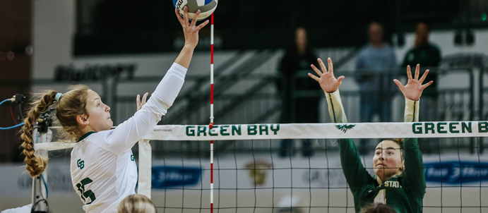 UW-Green Bay's Cora Behnke leaps up to hit the ball over the net in their game against Wright State on Saturday, Oct. 7. Submitted photos