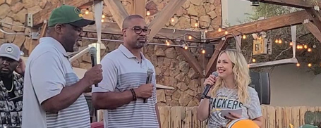 Packers linebacker alumni Bernardo Harris and Na'il Diggs are on stage with host Rebecca Zaccard at a Packers Everywhere pep rally Oct. 8 in Las Vegas