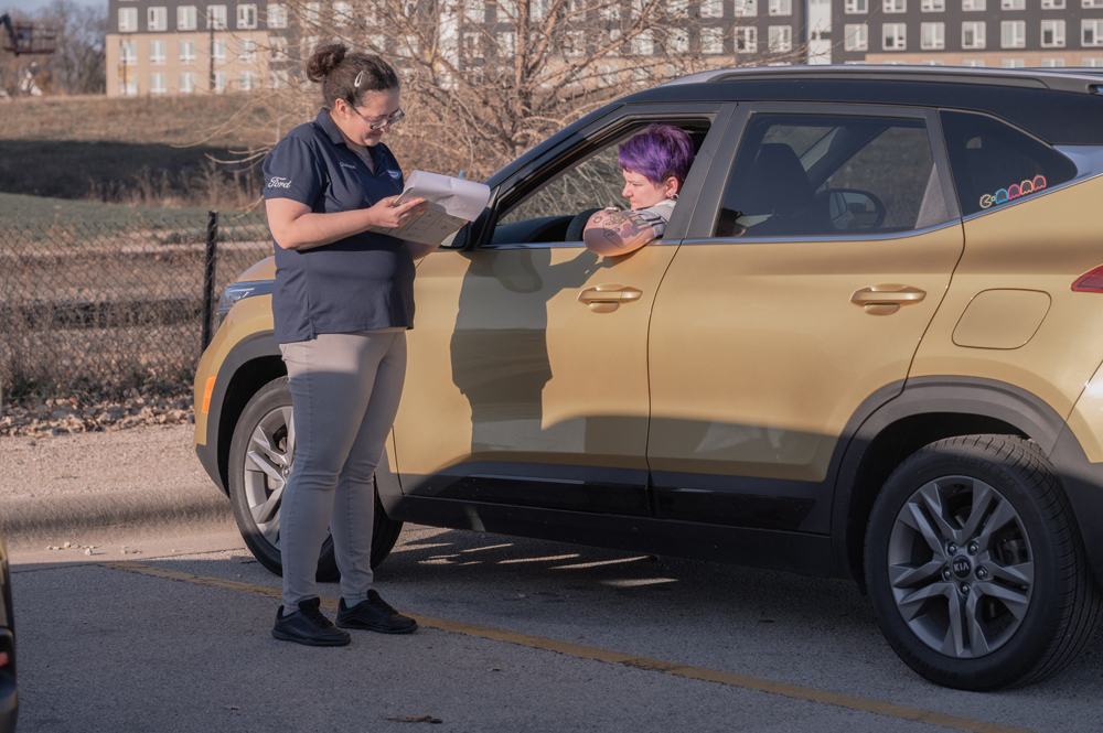 Tatum Haney, right, checks in with Chelsy Hardy of Dorsh Kia. Dorsh Kia and Bergstrom Hyundai of Green Bay volunteered staff to provide the free service to vehicle owners. Shane Fitzsimmons photo