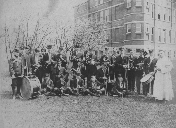 The 1910-11 St. Norbert College band, under the direction of director, Father Raphael Gerard Geven, poses next to Main Hall. St. Nobert College photo
