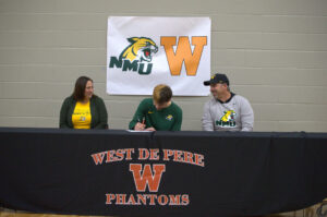 Kowalcyzk signs his national level of intent for Northern Michigan University to continue his soccer and schooling career.