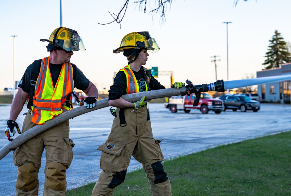 Randy Zahorik and Devyn Christensen, from the Wrightstown Fire Department, participate in the joint fire department exercise