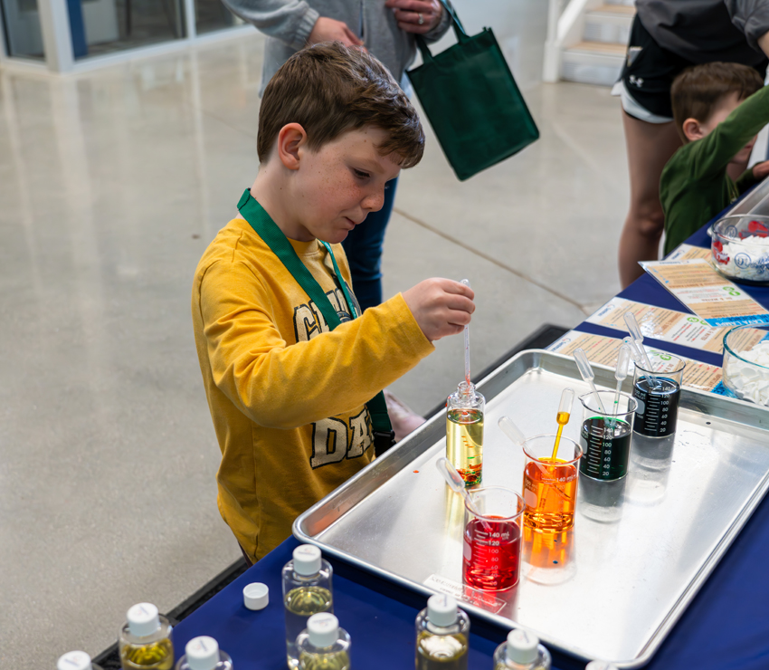 Max Schoenebeck makes a homemade lava lamp while learning about the interaction of different chemicals with Sanimax of Green Bay
